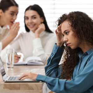 Persona LGTBI+ en el entorno laboral con expresión preocupada, simbolizando discriminación e injusticia